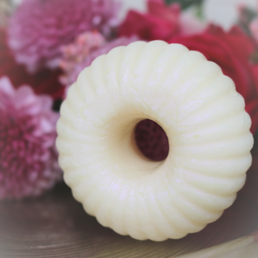 Close-up of the smooth, hand-poured texture of a tallow body lotion round featuring beeswax and cocoa butter.